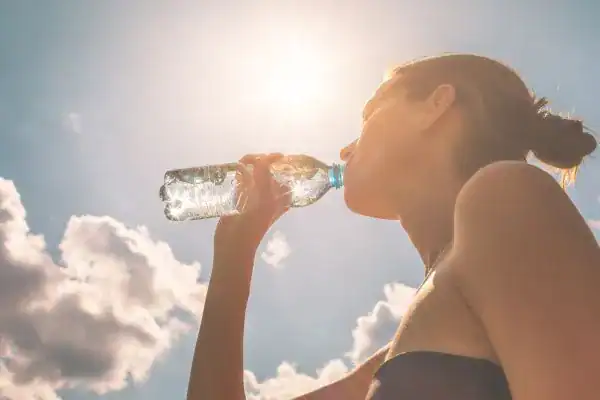 Hydration: The Secret Ingredient for a Toned Stomach and Enhanced Fitness 3 Image of woman drinking water to hydrate East Sussex after run.